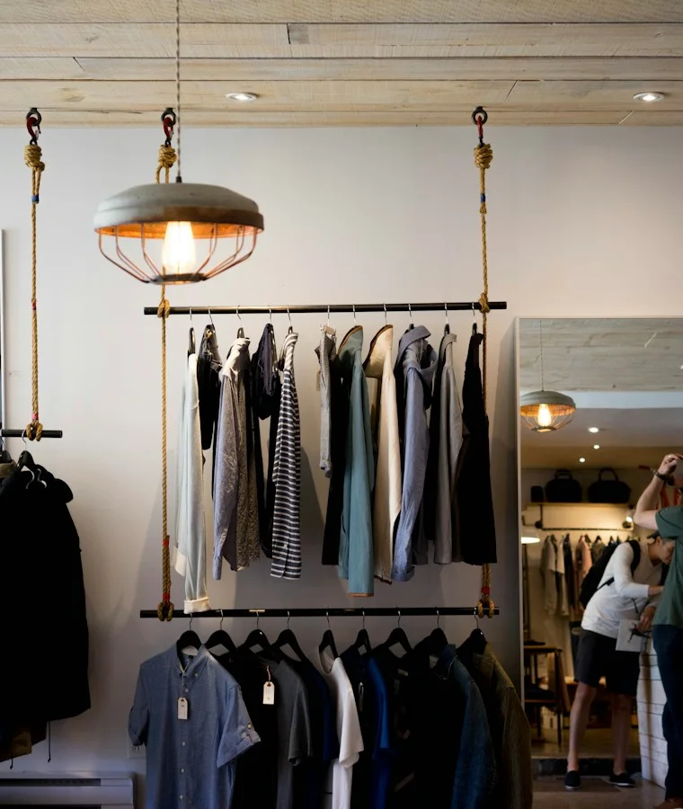 A sunlit independent clothing store with carefully arranged rails.