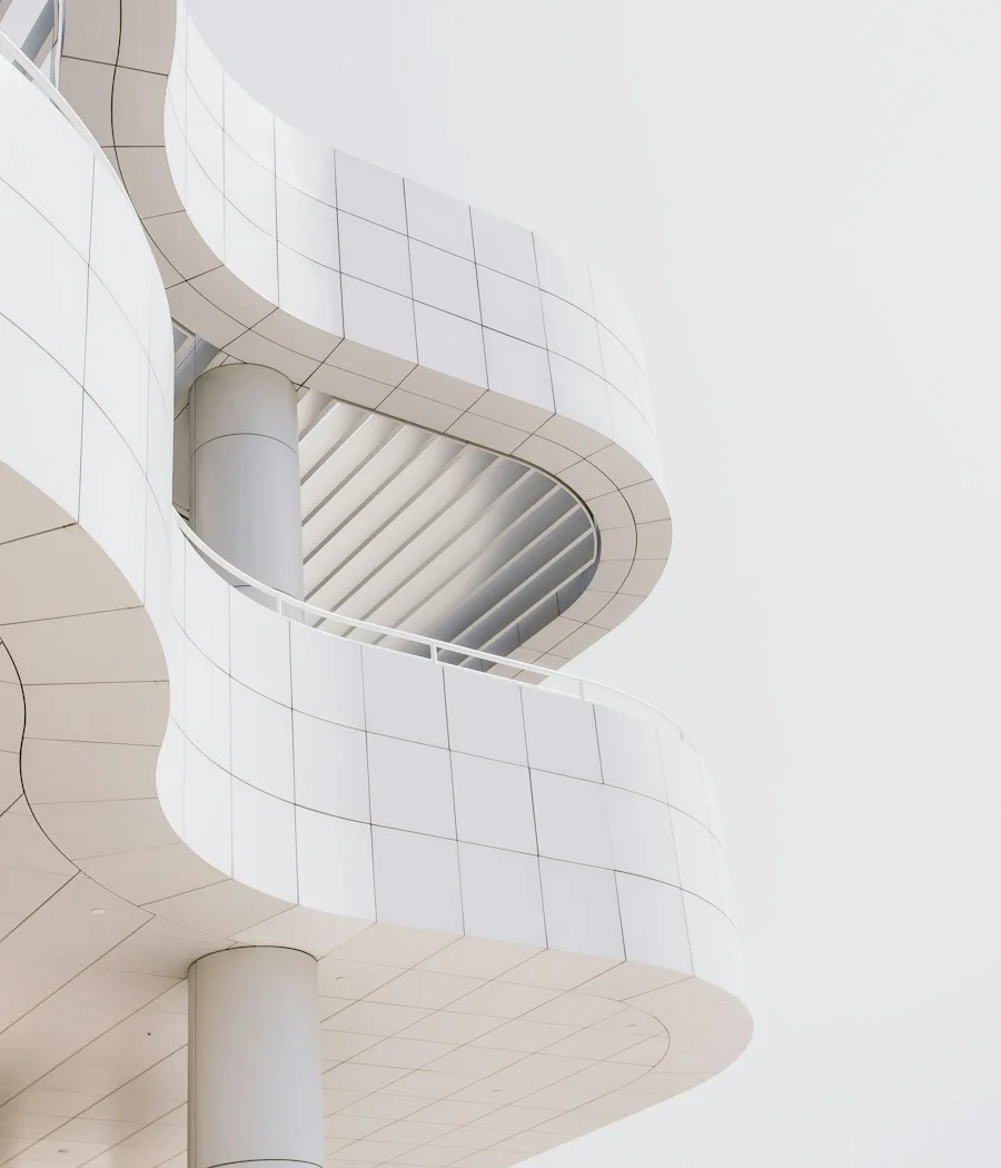 A sculptural white spiral staircase, photographed from below.